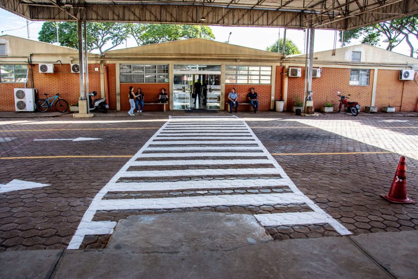 Pessoas caminham e aguardam na entrada de uma unidade comunitária em Londrina, no Paraná.