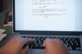 Mãos digitando um roteiro de filme em um laptop.
