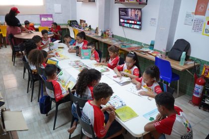 Crianças leem juntas em uma biblioteca comunitária no Brasil.