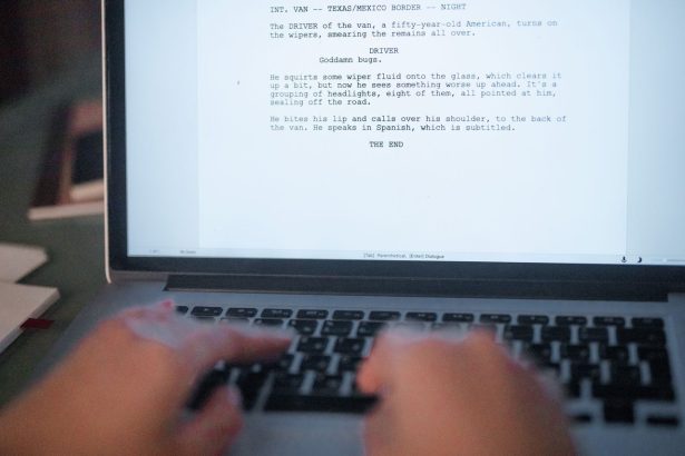 Mãos digitando um roteiro de filme em um laptop.