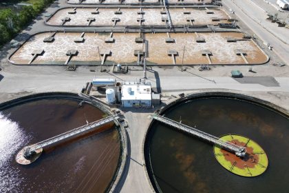 Vista aérea de uma estação de tratamento de água com grandes tanques circulares.