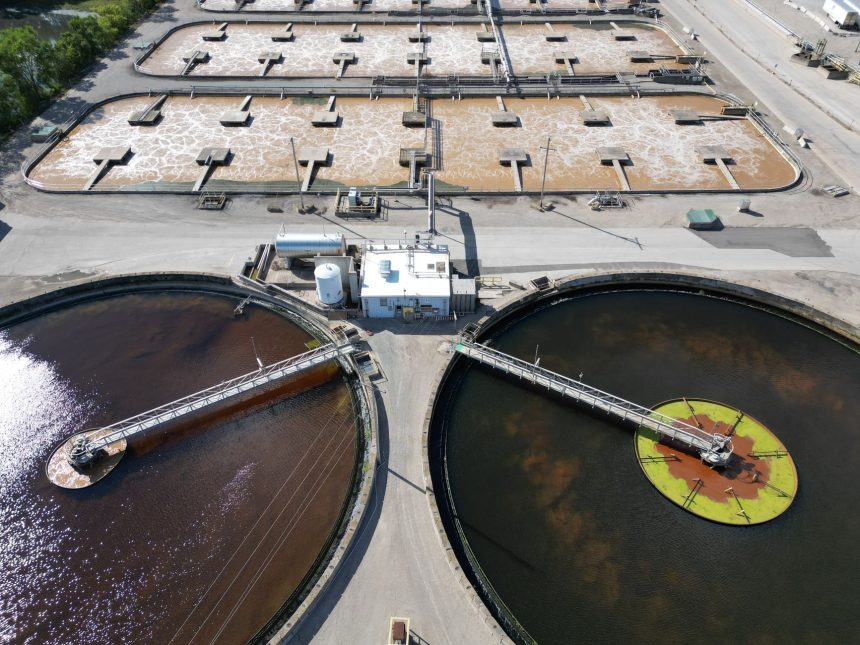 Vista aérea de uma estação de tratamento de água com grandes tanques circulares.